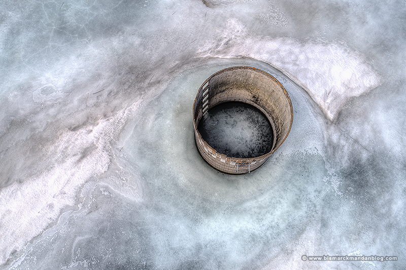 Abandoned brick silo surrounded by ice, viewed from above