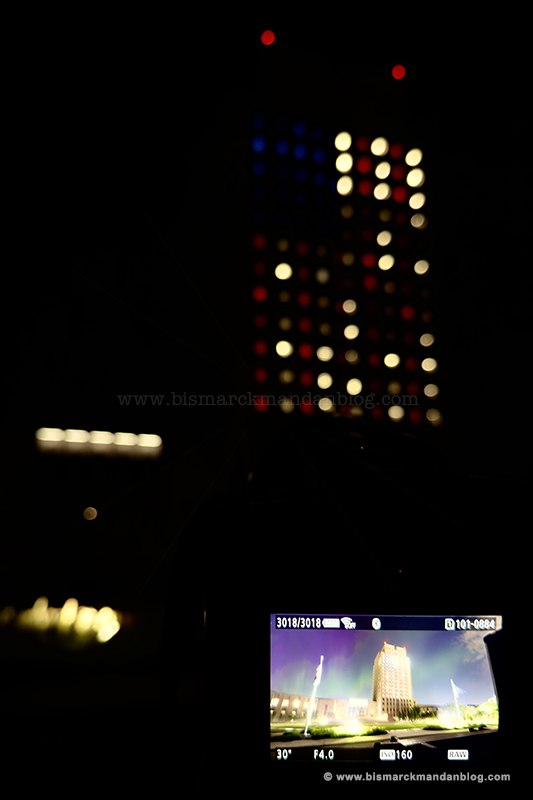 A cell phone photo of my camera's display with the capitol in the background. The display shows a photo of the capitol with northern lights in the sky behind it.