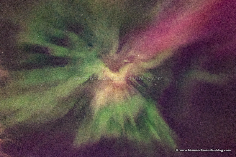 A swirling vortex of aurora borealis overhead